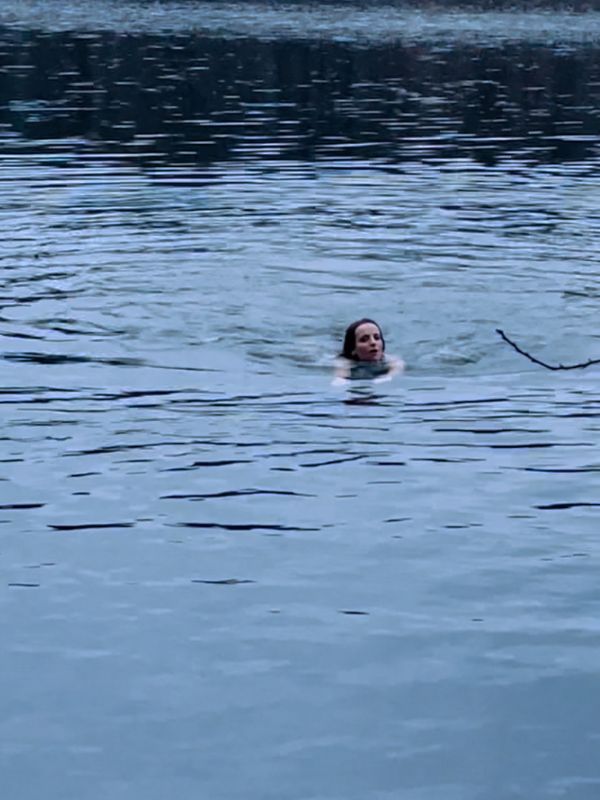A woman swimming in the lake in winter.
