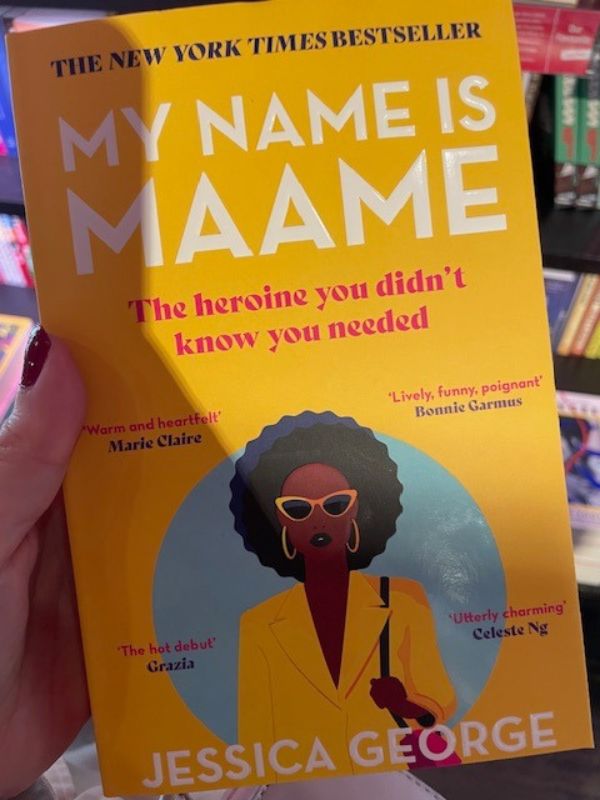 Book with yellow cover, showing an African Woman in a yellow blazer, with sunglasses and a beautiful afro. The book title is called "My Name is Maame" by Jessica George