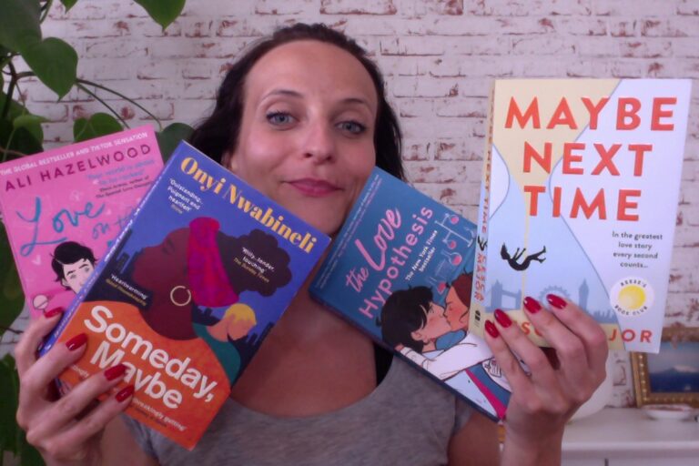 Woman holding 4 books in her hand, in each book she holds 2 books.