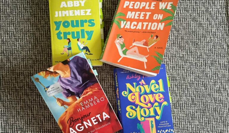 Four books are lying on the floor. The one in bright grean is called Yours truly, the book in orange color is titled People We Meet On Vacation, the book below that one in mostly blue color is titled is titled: A Novel Love Story, the book right next to that one has the title: Bonjour Agneta