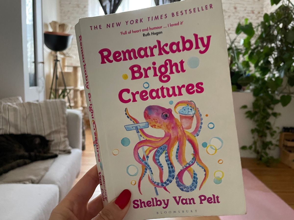 Hand holding up a book with the title: Remarkably Bright Creatures