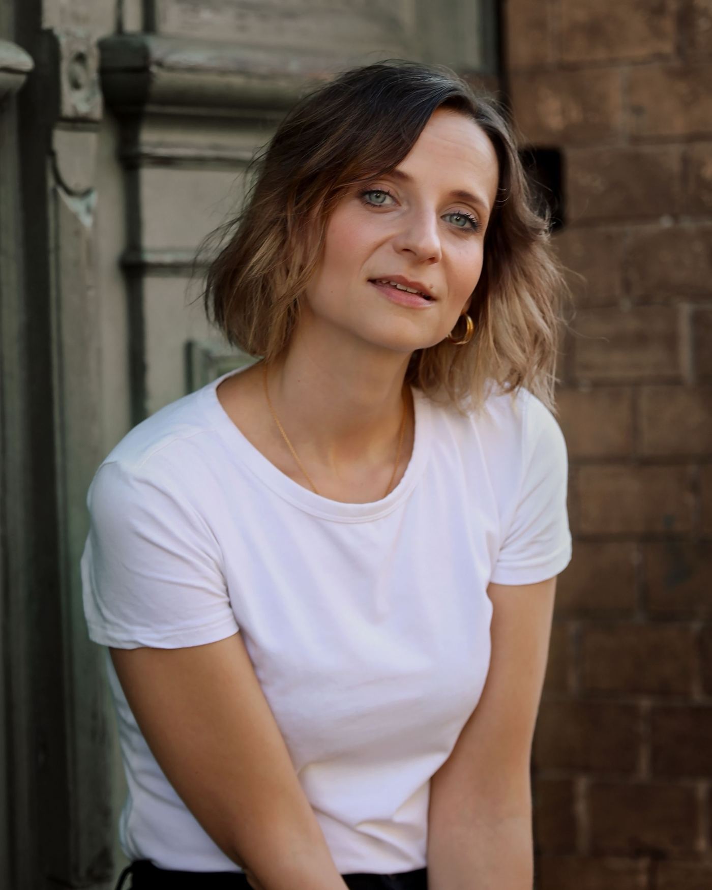 Nadine Kühn, close-up in front of a brick wall