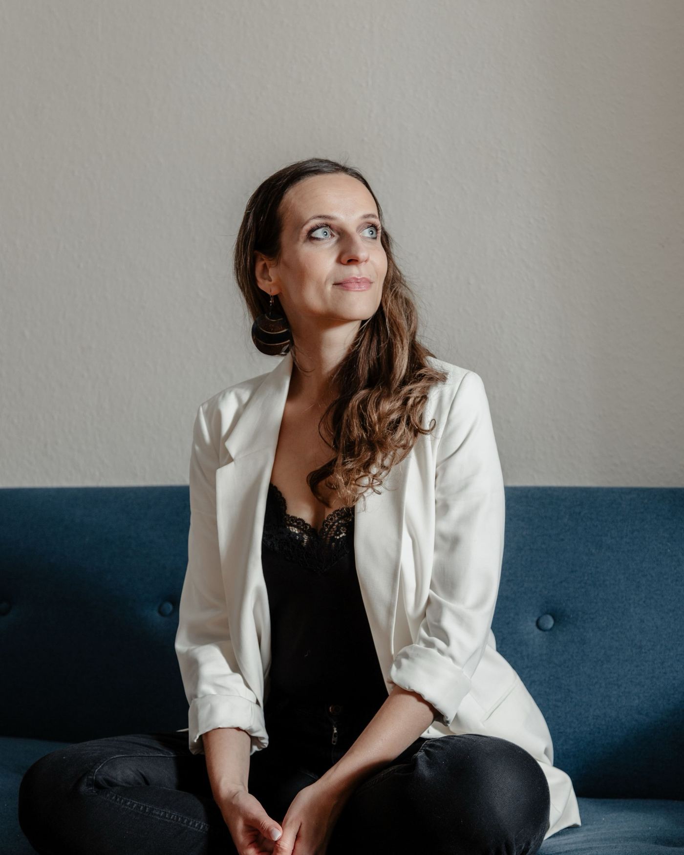 Nadine Kühn sitting on a sofa, looking up