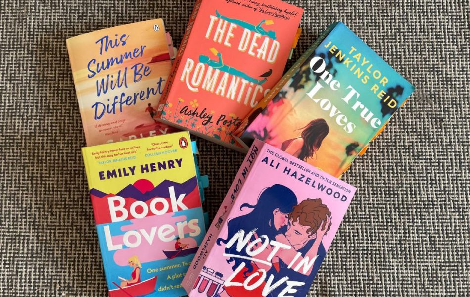 five books are beautifully assembled on the floor. They are all romance novels. The titles read (from right to left): 1. This Summer will be different 2. The Dead Romantics 3. One True Loves 4. Book Lovers 5. Not In Love