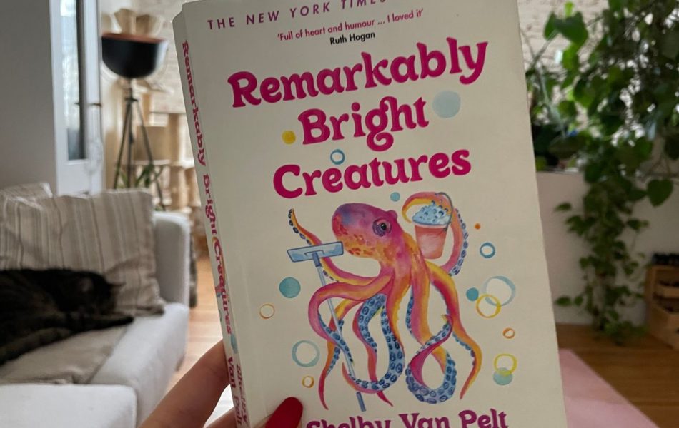 Hand holding up a book with the title: Remarkably Bright Creatures